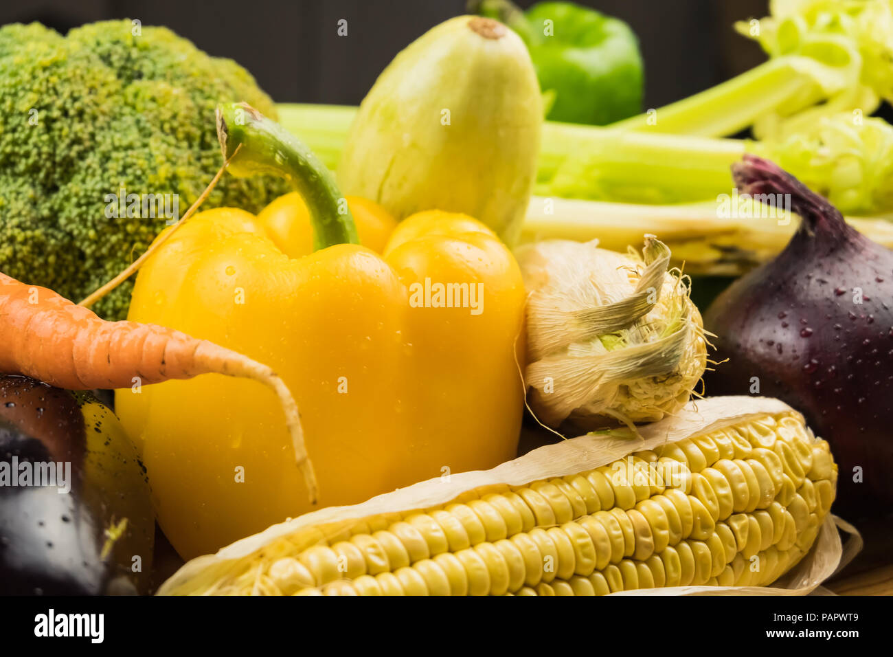 Locally grown bell pepper, corn and other natural vegan food laying on table. Close-up of fresh organic vegetables Stock Photo