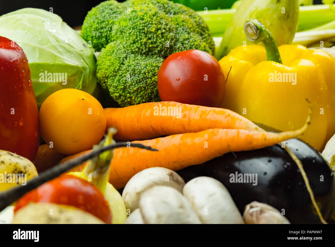 Close-up image of fresh organic vegetables. Locally grown bell pepper, corn, carrot, mushrooms and other natural vegan food laying on table. Stock Photo