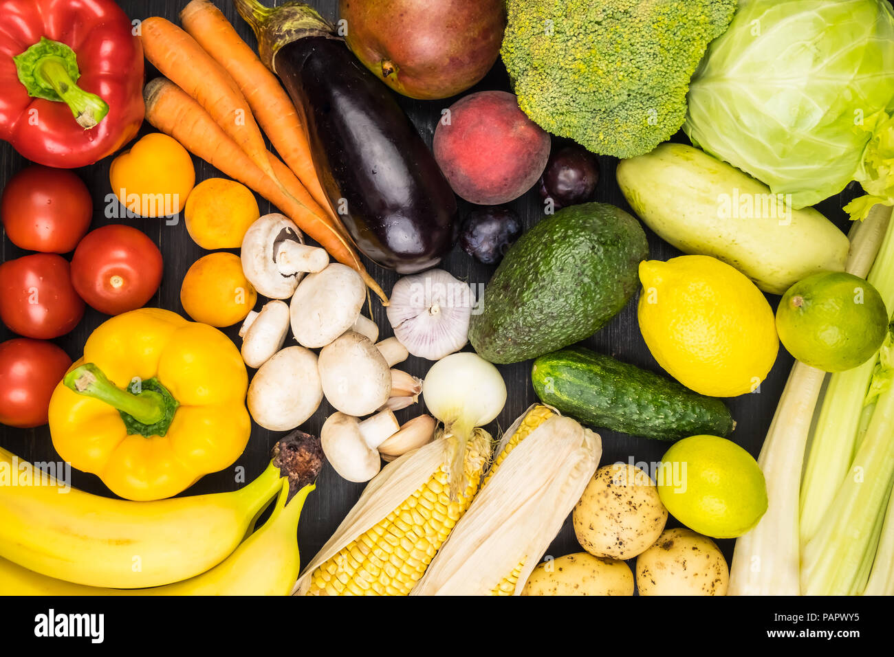 Close-up top view image of fresh organic vegetables and fruit. Locally grown bell pepper, corn, carrot, mushrooms and other natural vegan food laying  Stock Photo