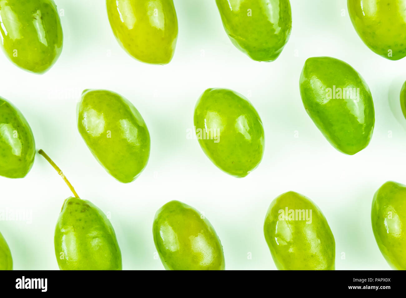 Bright top view pattern of fresh green olives on white background. Shot from above of multiple olives Stock Photo