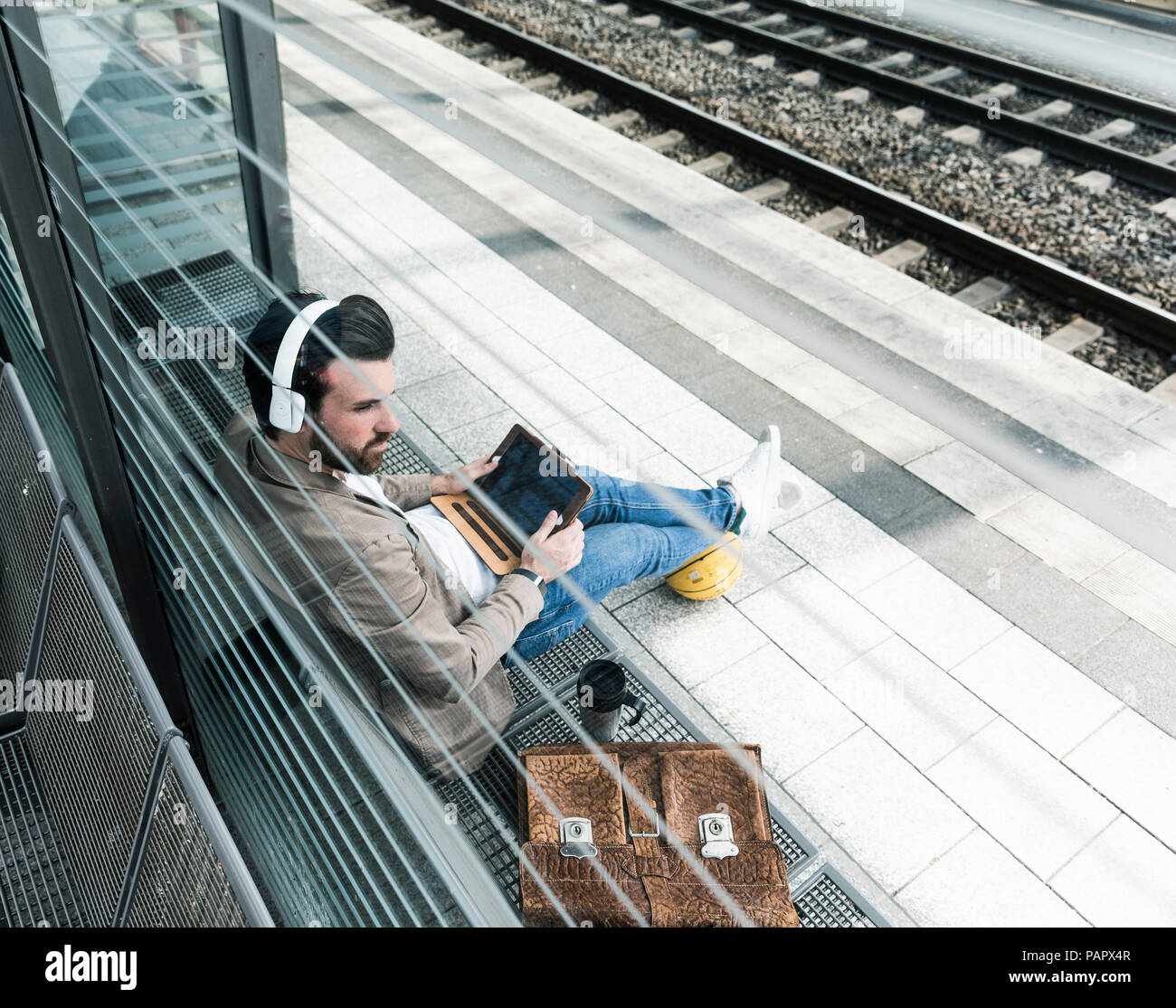 Young man with basketball using tablet at the station platform Stock Photo