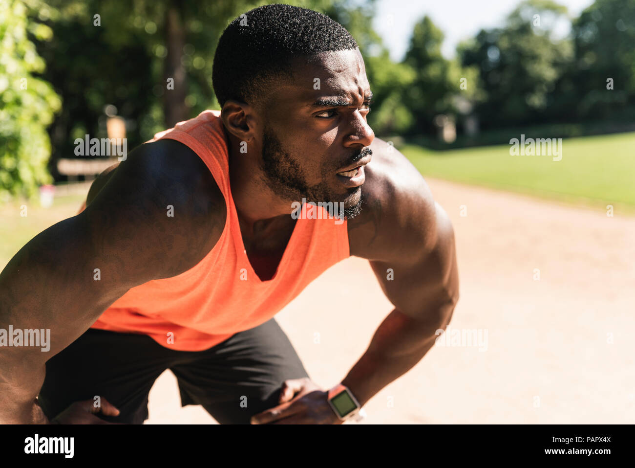 Young athlete exercising on sports field, concentrating Stock Photo
