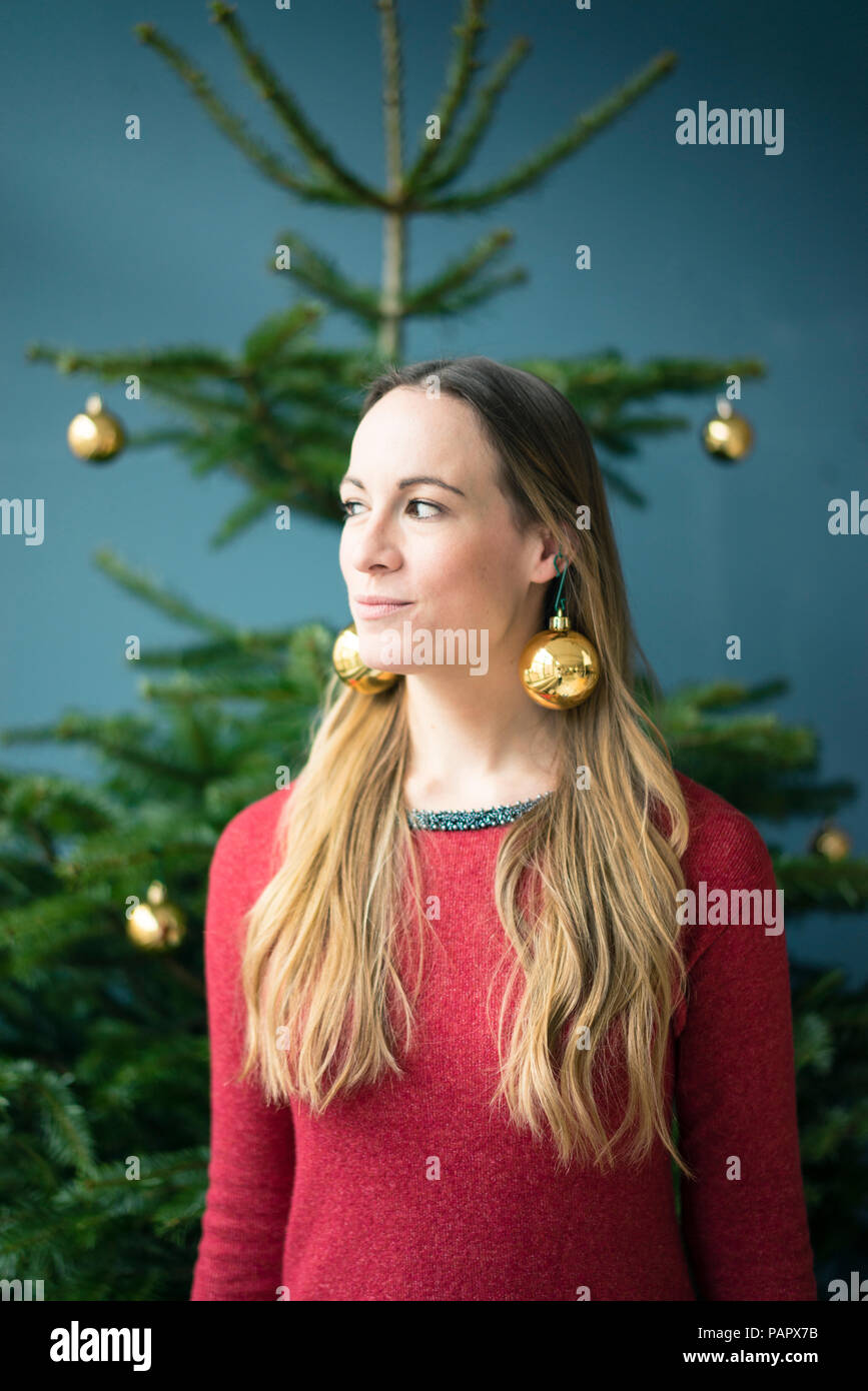 Portrait of woman wearing golden Christmas baubles earrings Stock Photo