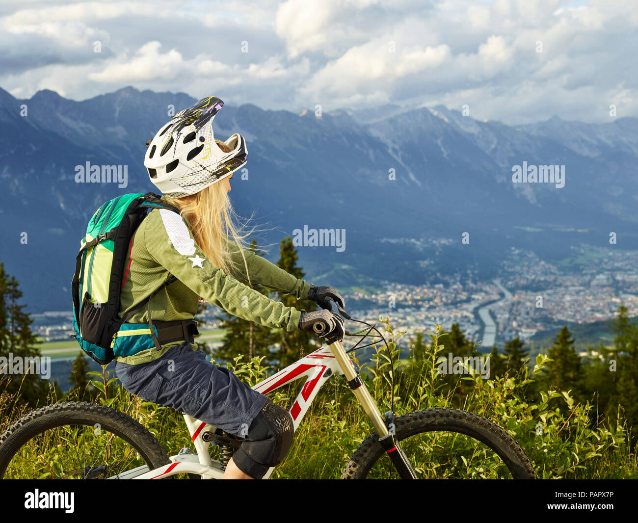 Austria, Tyrol, female downhill mountain biker looking into valley Stock Photo