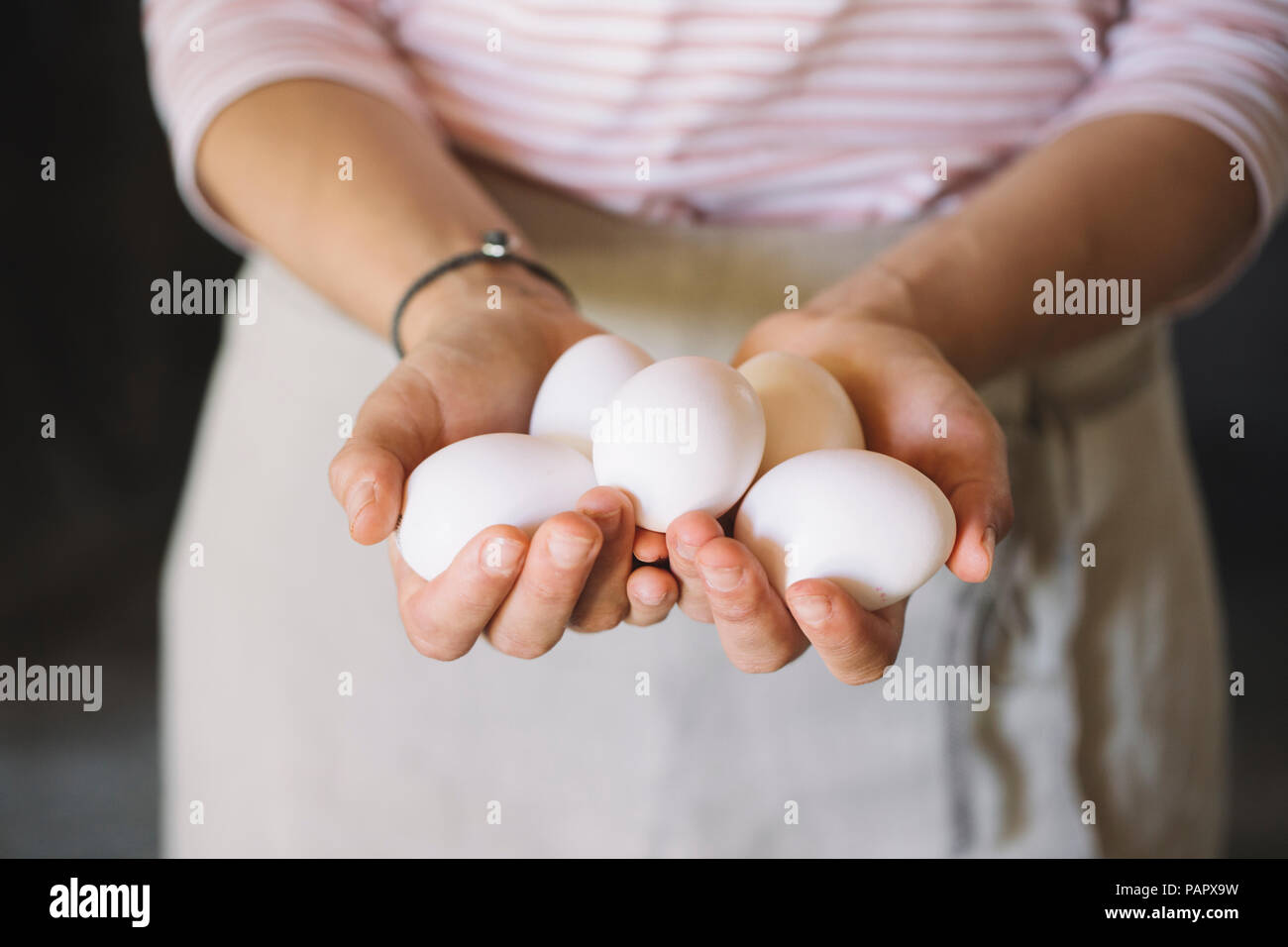 Woman holding raw white eggs Stock Photo