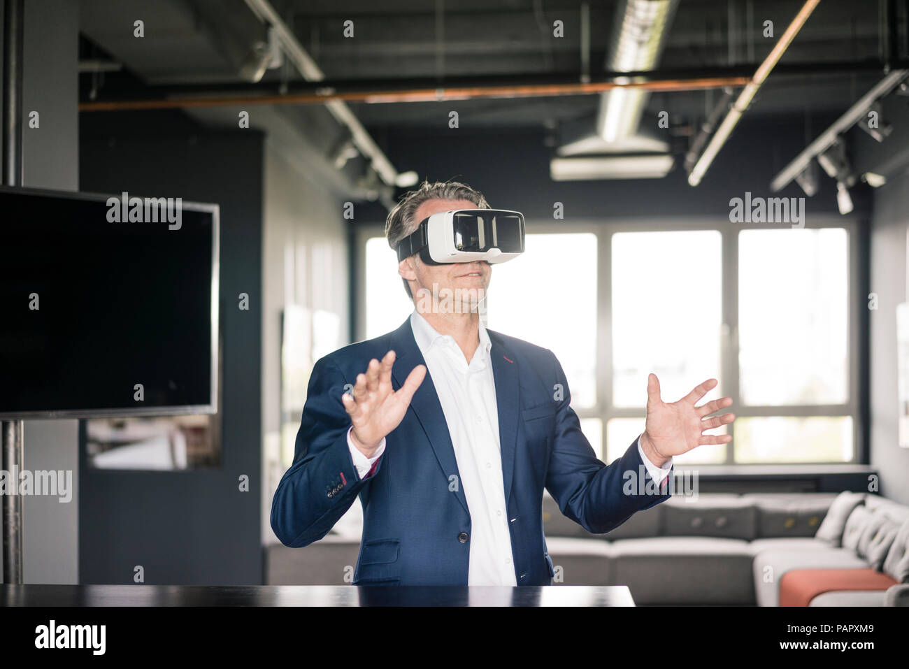 Mature businessman wearing VR glasses Stock Photo - Alamy