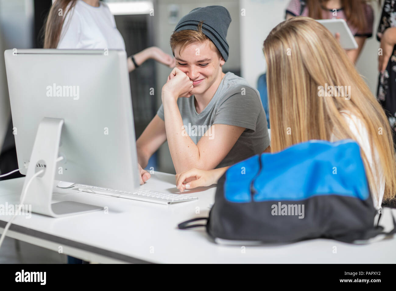 Students working on computer in class together Stock Photo