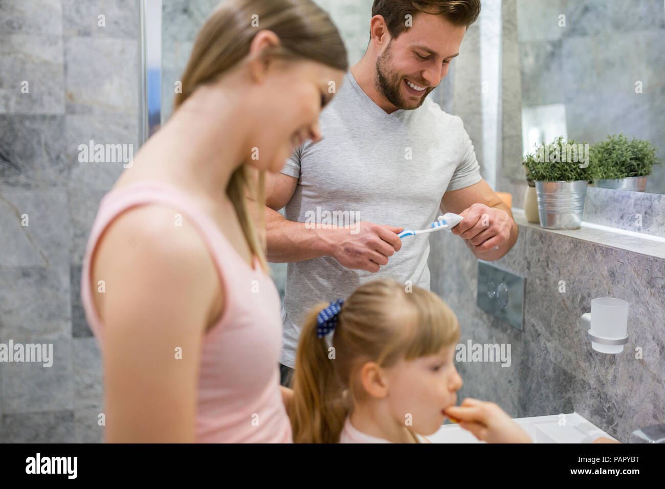 Happy family brushing teeth together Stock Photo