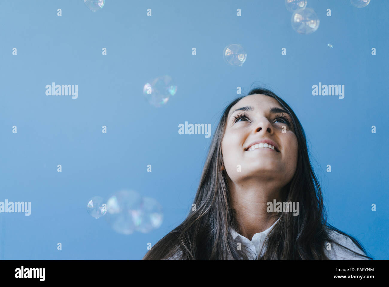 Pretty young woman playing with soap bubbles Stock Photo