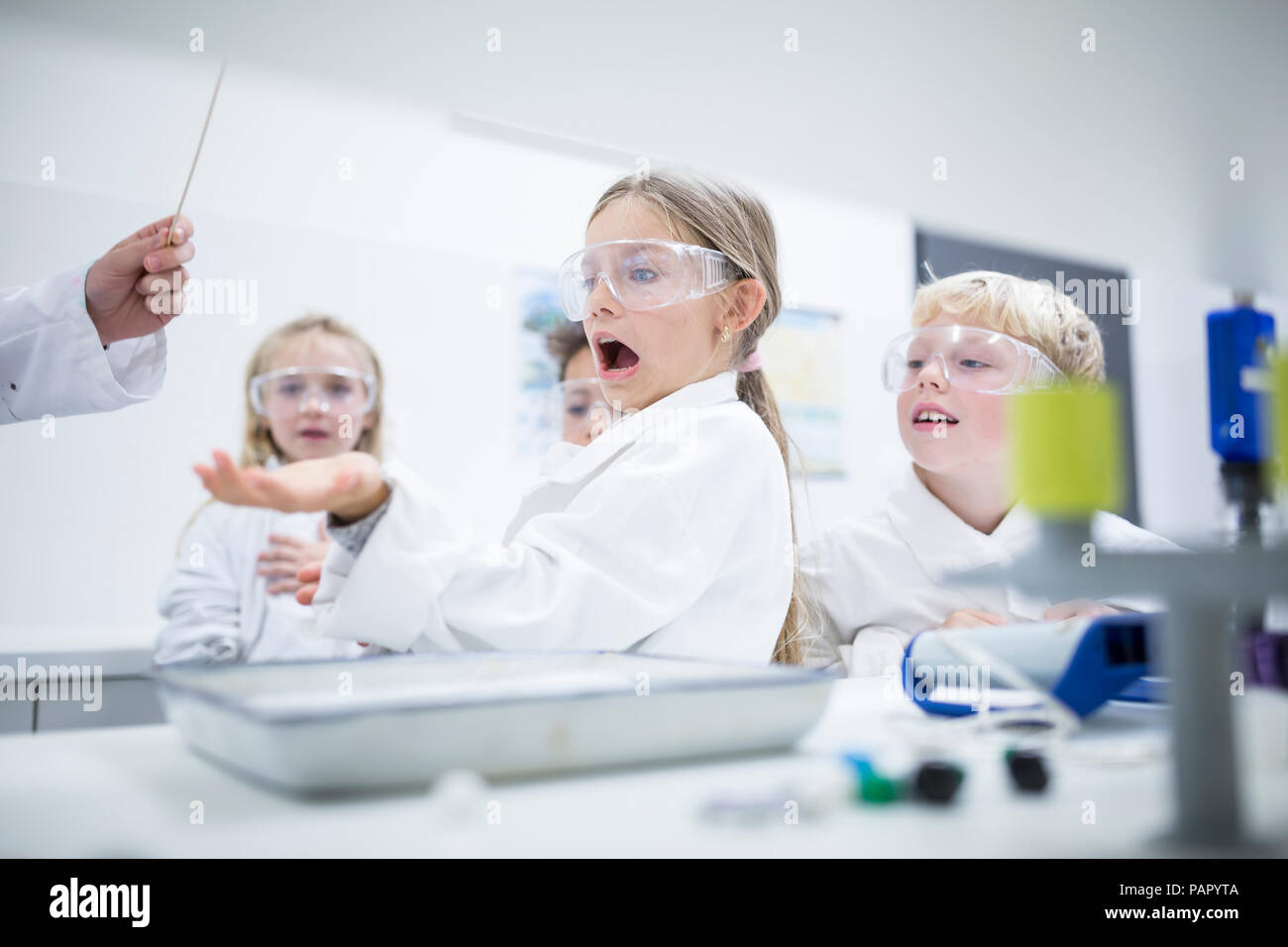 Frightened schoolgirl in science class Stock Photo