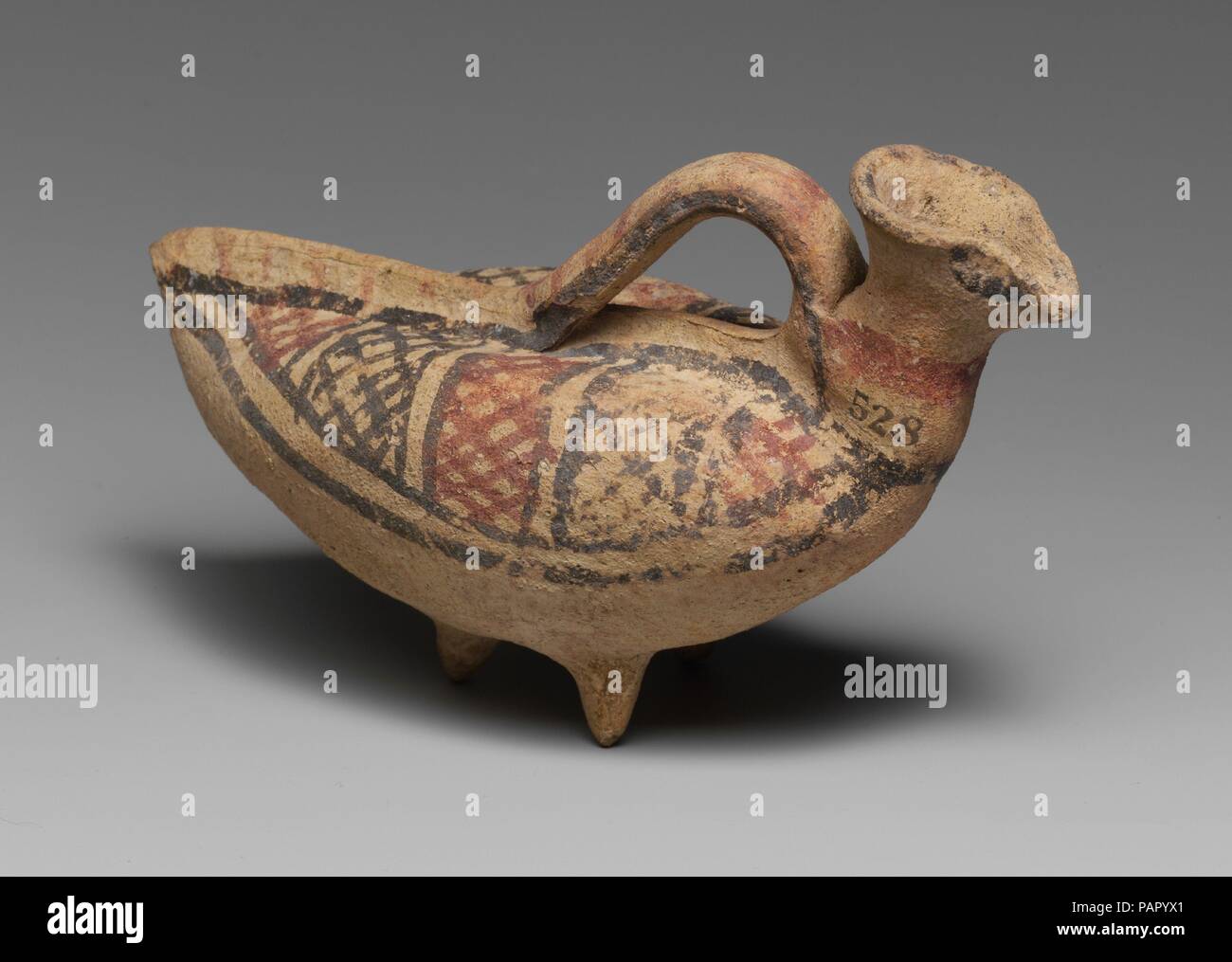 Terracotta askos (flask with a spout and handle over the top) in the form of a bird. Culture: Cypriot. Dimensions: 3 3/8in. (8.6cm). Date: 750-600 B.C..  Three feet with geometric ornament. Museum: Metropolitan Museum of Art, New York, USA. Stock Photo