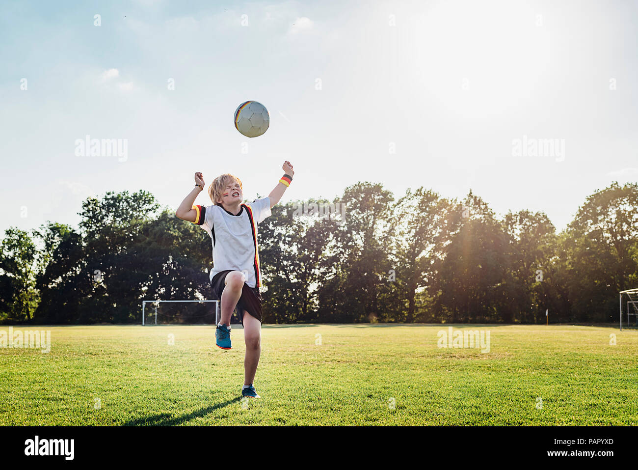 Boy wearing German football shirt playing soccer Stock Photo