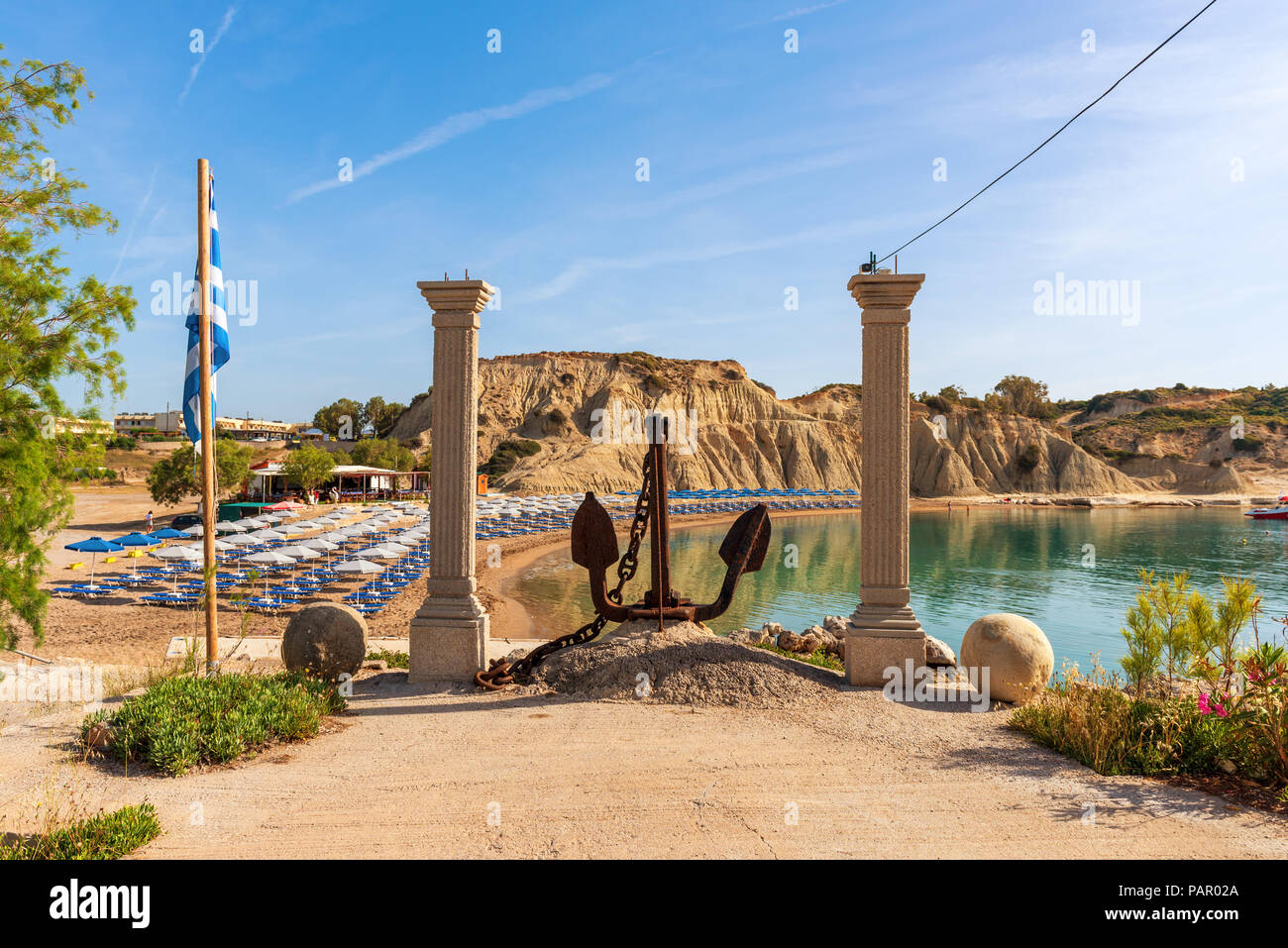 Ancient columns with anchore at harbor in Kolymbia village. Rhodes island. Greece Stock Photo