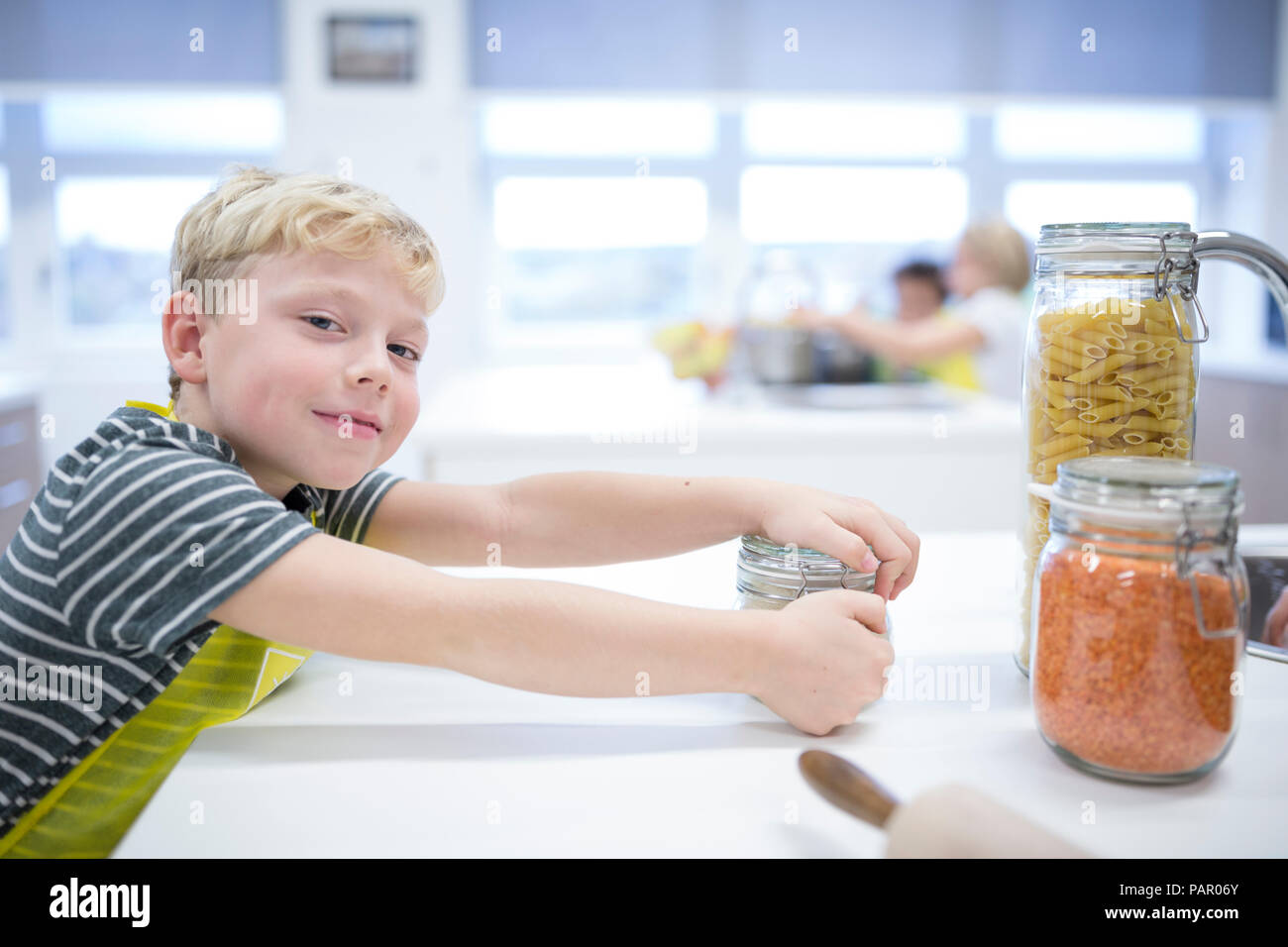 Portrait of smiling schoolboy in cooking class Stock Photo