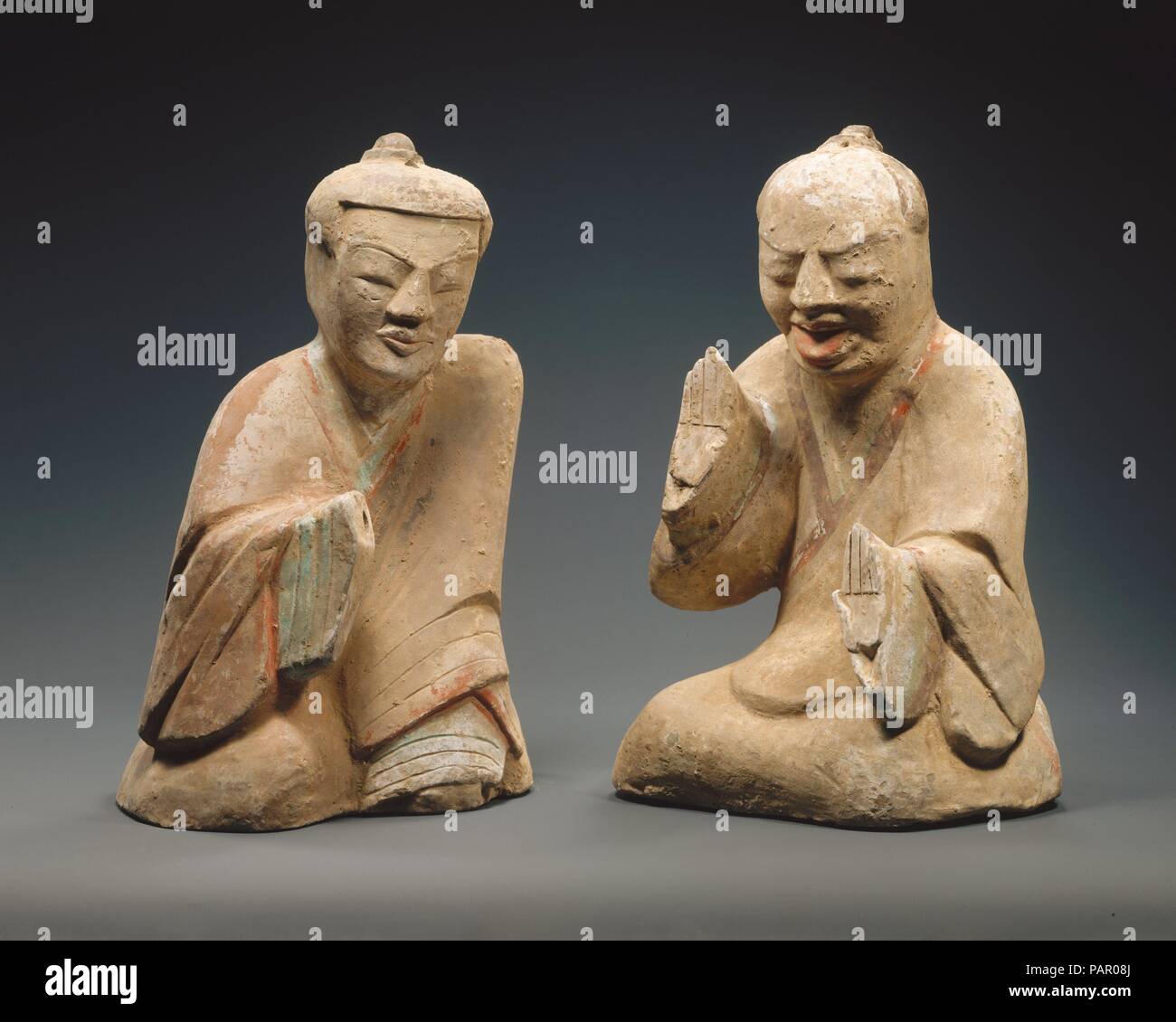 Pair of Seated Figures Playing Liubo. Culture: China. Dimensions: a: H. 13 13/16 in. (35.1 cm); b: H. 13 5/8 in. (34.6 cm). Date: 1st century B.C.-1st century A.D..  Both written records and archaeological finds attest to the popularity of the game of liubo (sometimes translated 'six rods') during the Han dynasty. A board divided into roads, and twelve pieces (six for each players) and dice thrown to determine moves, constitute the basic equipment for the game. It is thought the pattern on the board has cosmological significance illustrative of earlier traditions of divinatory casting. Museum: Stock Photo