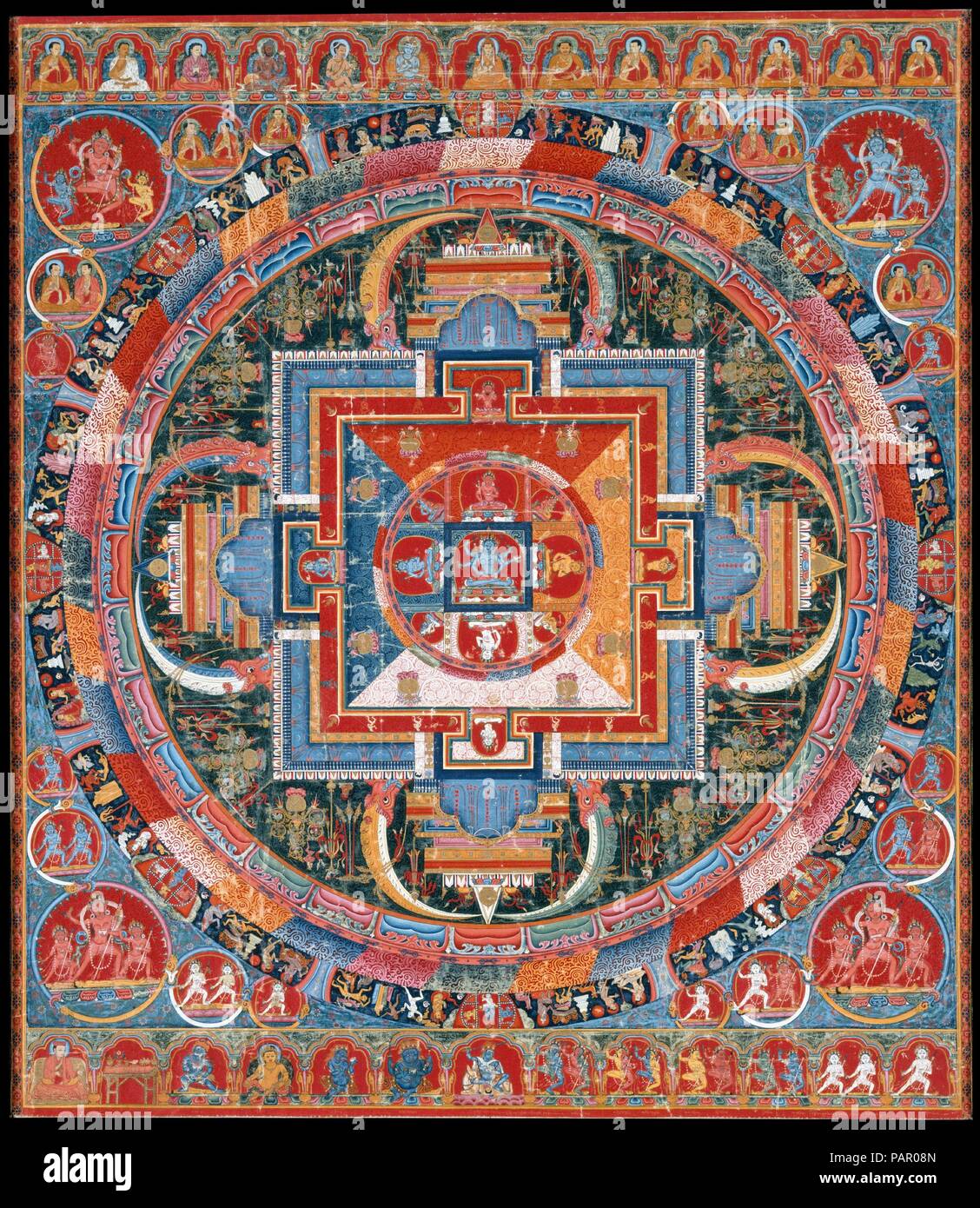 Mandala of Jnanadakini. Culture: Tibet. Dimensions: Image: 29 1/2 x 33 in. (74.9 x 83.8 cm)  with traditional textile mount: 54 1/8 x 36 1/4 in. (137.5 x 92.1 cm)  Framed: 49 1/2 in. × 37 13/16 in. × 1 in. (125.7 × 96 × 2.5 cm). Date: late 14th century.  The central six-armed goddess (devi), Jnanadakini, is surrounded by eight emanations--representations of the devi that correspond to the colors of the mandala's four directional quadrants. Four additional protective goddesses sit within the gateways. Surrounding the mandala are concentric circles that contain lotus petals, vajras, flames, and  Stock Photo