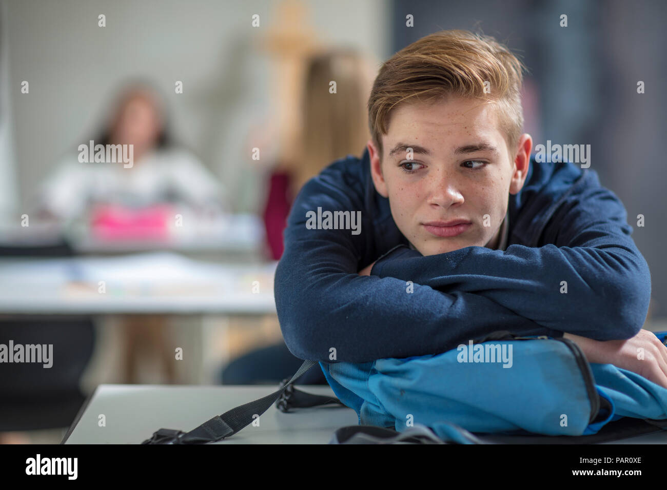 Serious teenage boy thinking in class Stock Photo