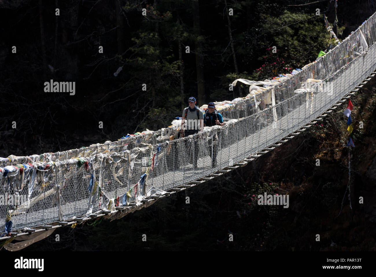 Nepal, Solo Khumbu, Everest, Sagamartha National Park, Two people crossing suspension bridge Stock Photo