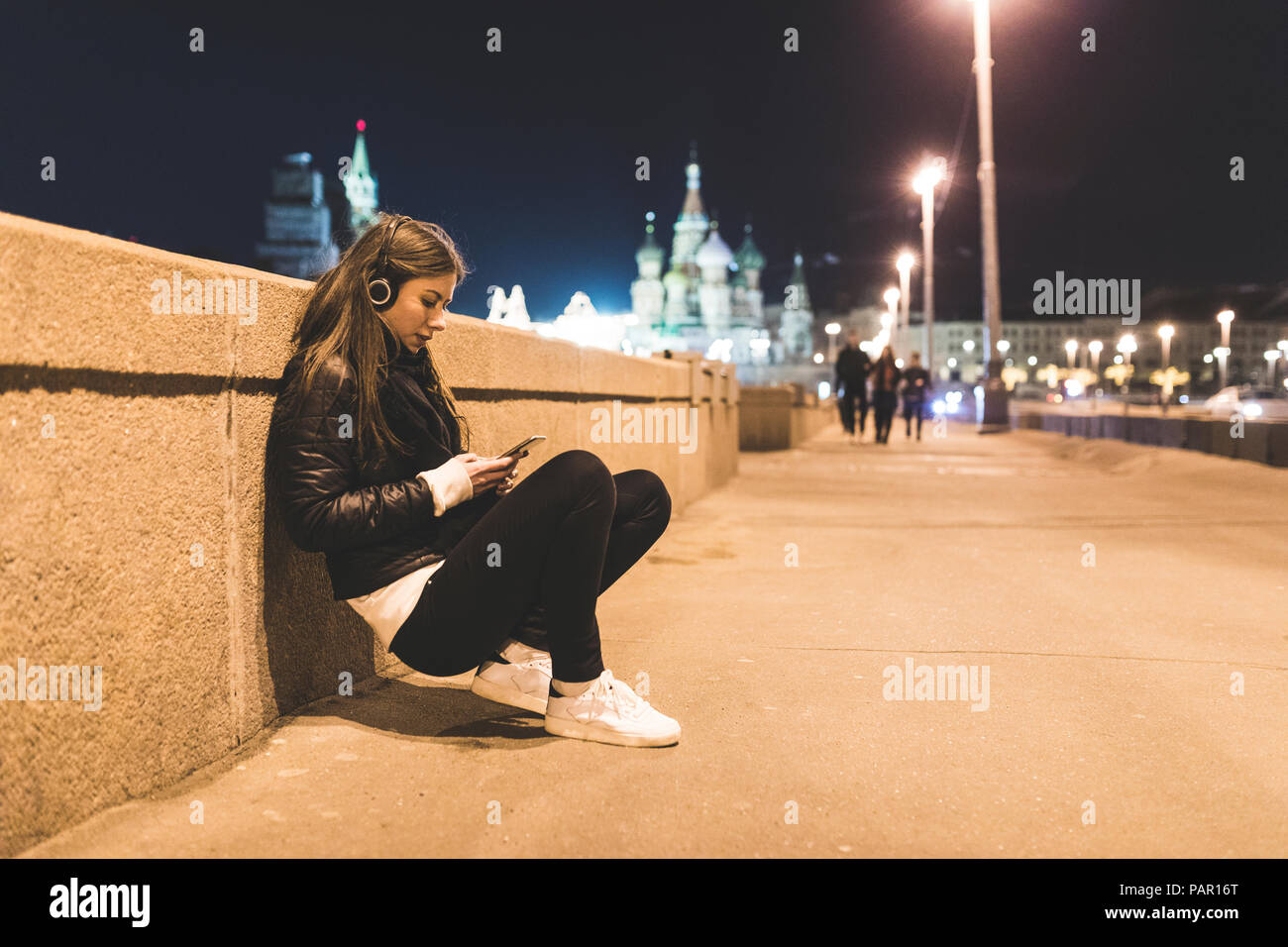 Russia, Moscow, beautiful woman listening music in the city at night Stock Photo