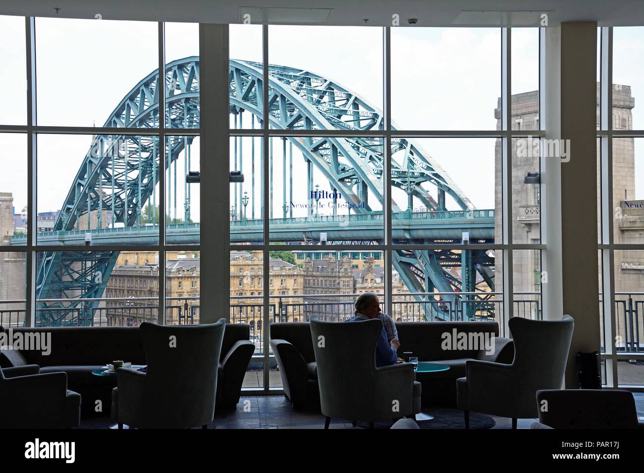 People sitting in the bar of the Hilton Hotel in Gateshead with view of the Tyne Bridge across the River Tyne, Newcastle upon Tyne, Tyne and Wear, Eng Stock Photo