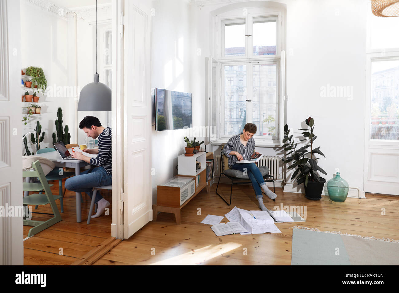 Couple sitting at home, sorting files with documents Stock Photo