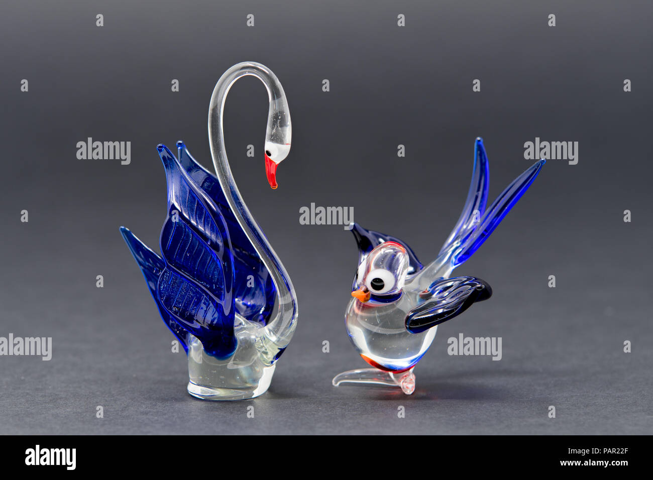 Two glass bird ornaments, made with clear, blue and red glass
