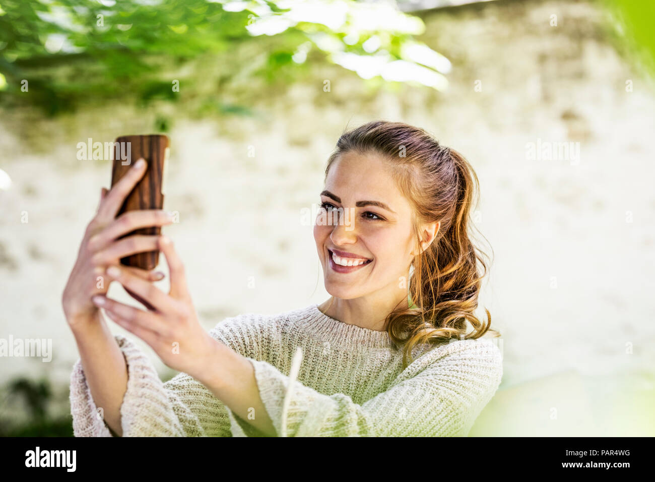 Portrait of relaxed woman taking selfie with cell phone Stock Photo