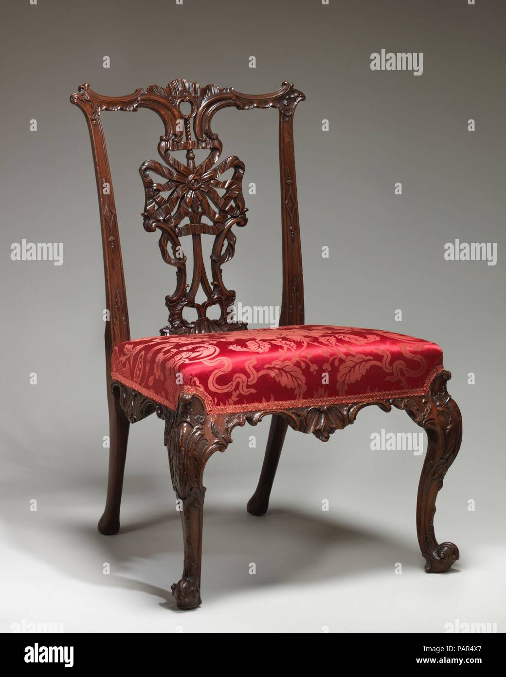 Side chair. Culture: British. Dimensions: Overall: 37 7/8 × 25 1/4 × 24 3/4 in. (96.2 × 64.1 × 62.9 cm). Date: mid-18th century.  The design is based on one of several 'ribband-back chairs' in the first edition of Thomas Chippendale's influential book, The Gentleman and Cabinet-Maker's Director of 1754. The preparatory drawing for this plate, which also appeared in the editions of 1755 and 1762, is in the Drawings Department at The Metropolitan Museum of Art. Museum: Metropolitan Museum of Art, New York, USA. Stock Photo