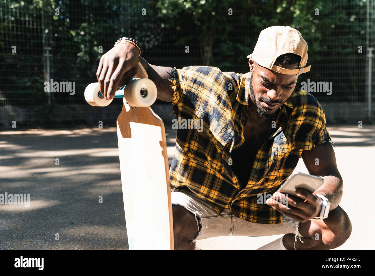 Cool young man in skate park, using smartphone Stock Photo