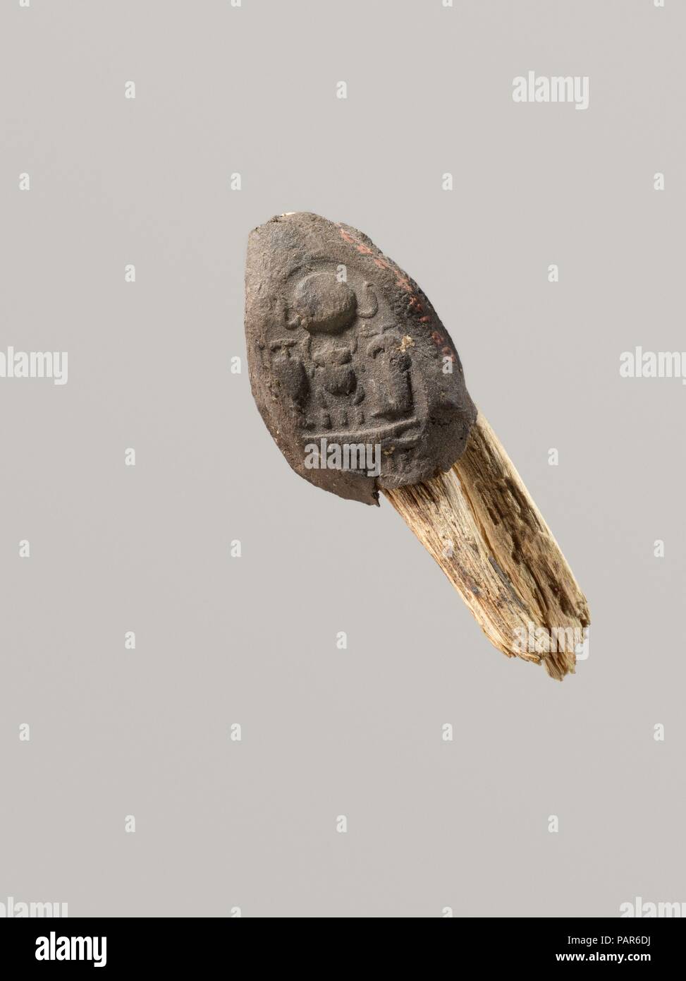 Seal Impression Attatched to a Fiber Tie from Tutankhamun's Embalming Cache. Dimensions: Seal and tie: L. 4.2 cm (1 5/8 in.)  Seal: L. 2.5 cm (1 in.); W. 1.8 cm (11/16 in.). Dynasty: Dynasty 18. Reign: reign of Tutankhamun. Date: ca. 1336-1327 B.C..  This mud sealing is still attached to a piece of the papyrus tie that was used to secure a container. The impression preserves the throne name of Tutankhamun, Nebkheperure, and the epithets 'beloved of Khnum' and 'manifold of praises.'   For a similar impression, see 09.184.263. Museum: Metropolitan Museum of Art, New York, USA. Stock Photo