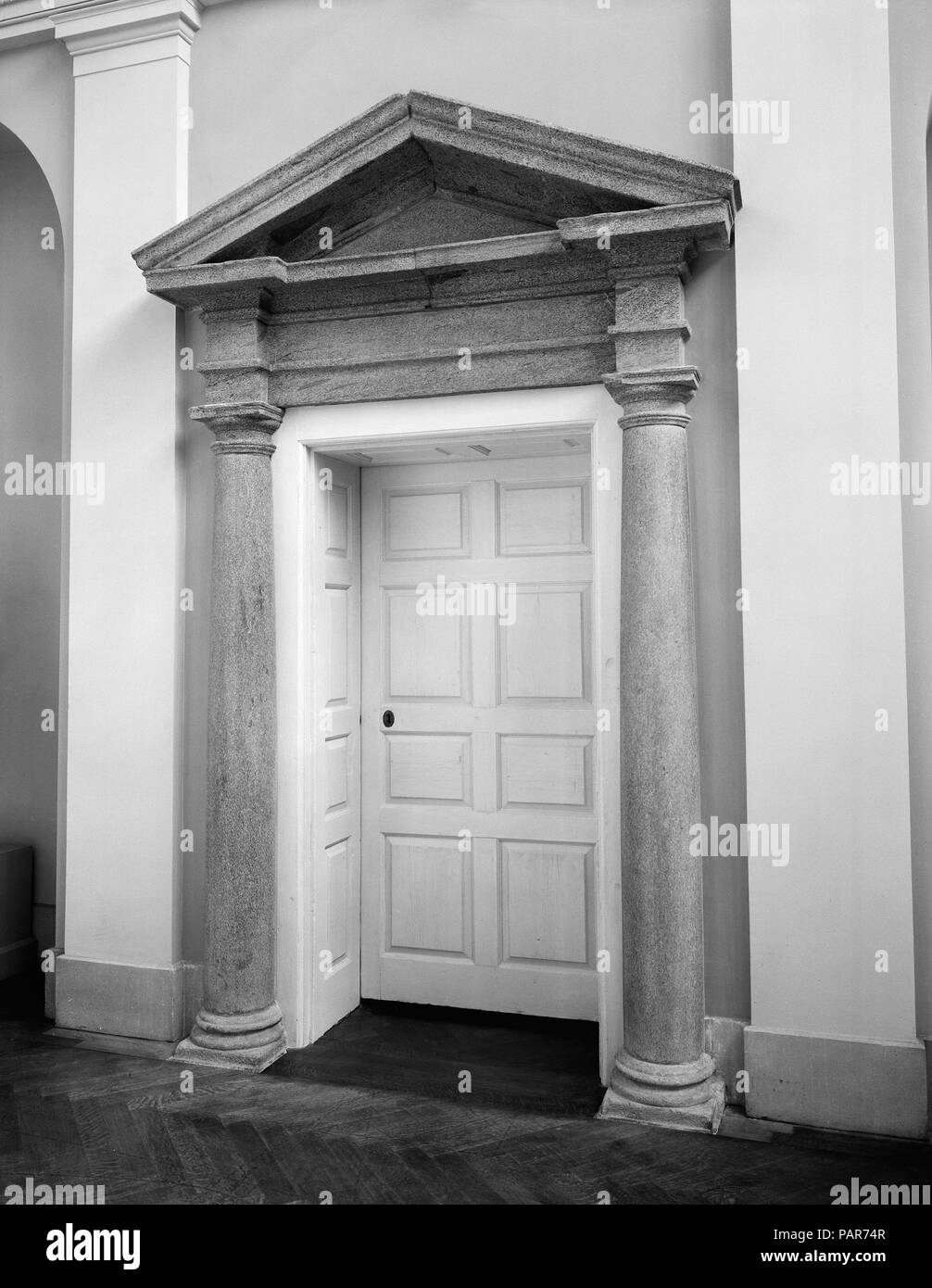 Doorway from Chalkley Hall, Frankford, Pennsylvania. Culture: American. Dimensions: Door: 96 x 47 in. (243.8 x 119.4 cm)  Portal: 146 x 84 in. (370.8 x 213.4 cm). Date: ca. 1776.  This granite and wood doorway was the former entrance to Chalkley Hall, a house formerly located at Frankford, Pennsylvania, near Philadelphia. The main portion of the house, including the doorway, was erected in about 1776 for Abel James, a Philadelphia merchant. It was attached to a smaller, lower wing built in 1723 by Thomas Chalkley, merchant, ship owner, and Quaker missionary, whose daughter married Abel James.  Stock Photo