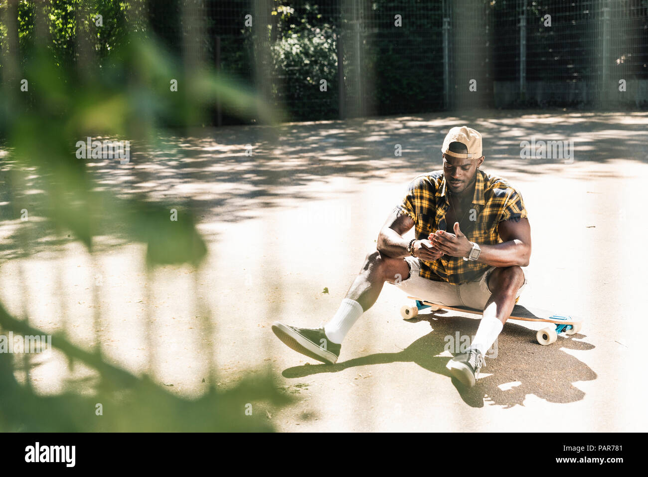 Cool young man in skate park, using smartphone Stock Photo