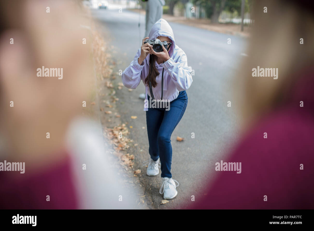 Teenage girl taking a picture of her friends on the street Stock Photo