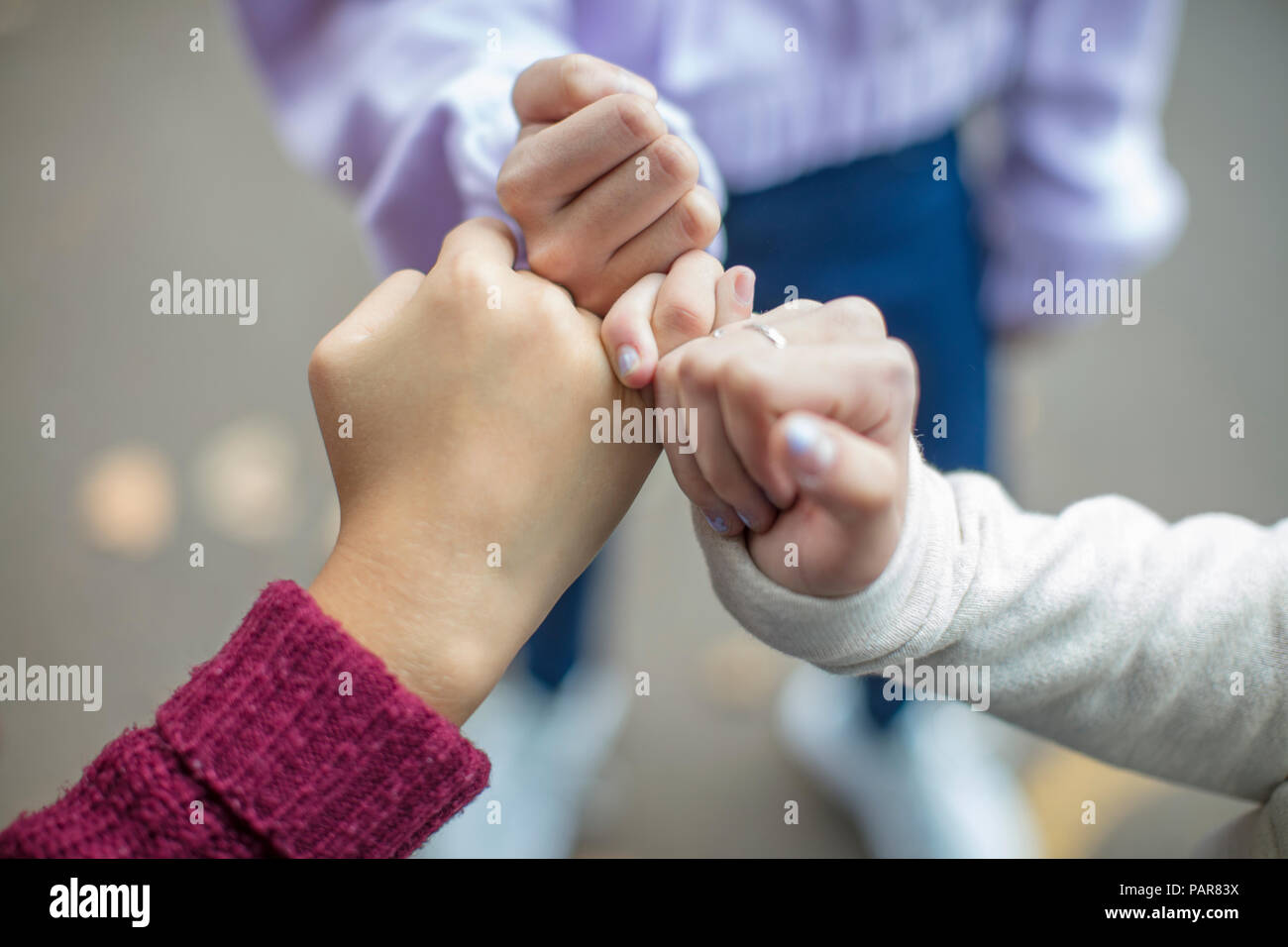 Close-up of teenage girls making a pinky promise Stock Photo