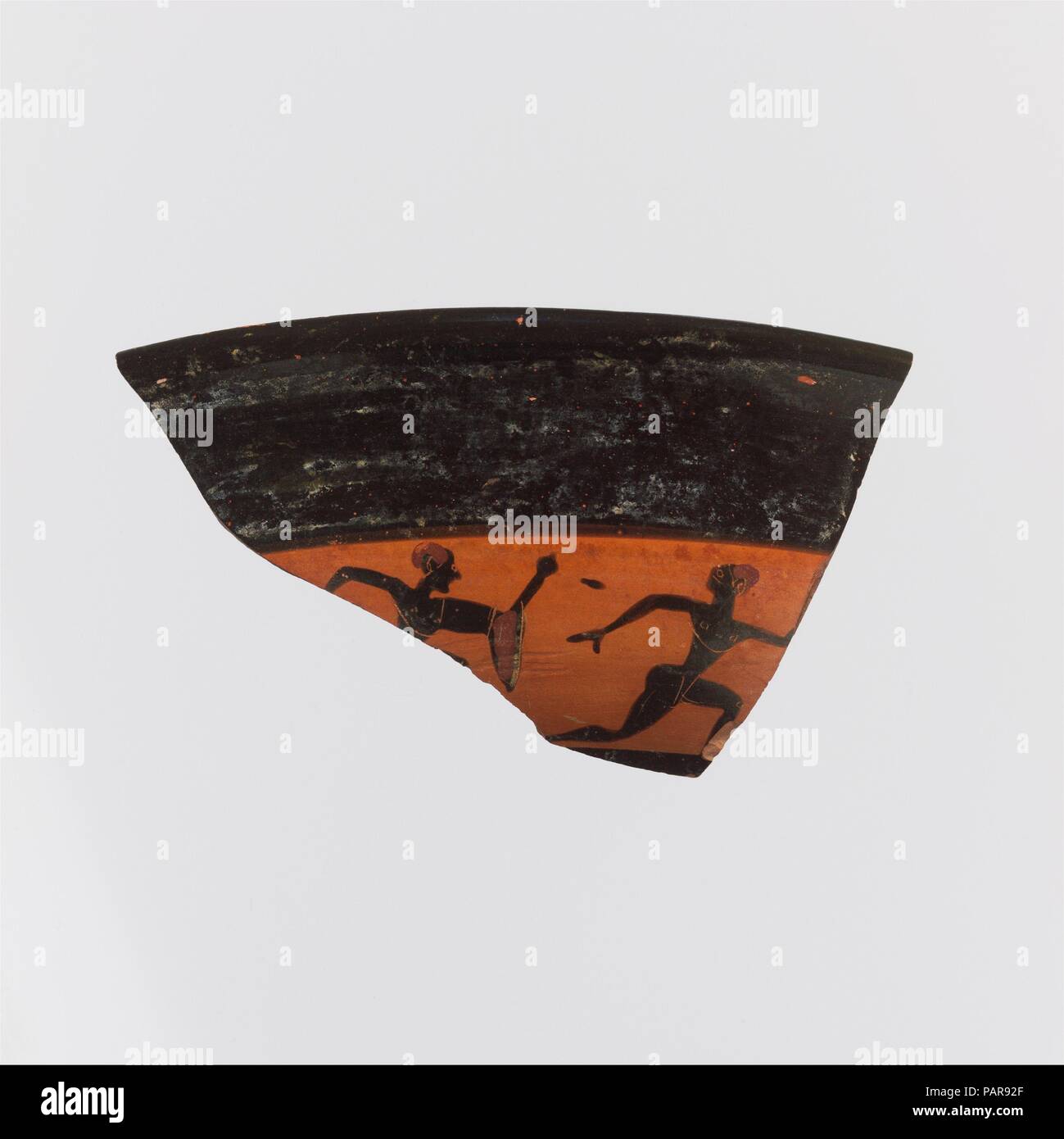 Fragment of a kylix: band-cup (drinking cup). Culture: Greek, Attic. Dimensions: Overall: 1 3/4 x 3 15/16in. (4.5 x 10cm). Date: ca. 540 B.C..  Parts of two youths running full speed; one has chlamys draped over arm. Museum: Metropolitan Museum of Art, New York, USA. Stock Photo