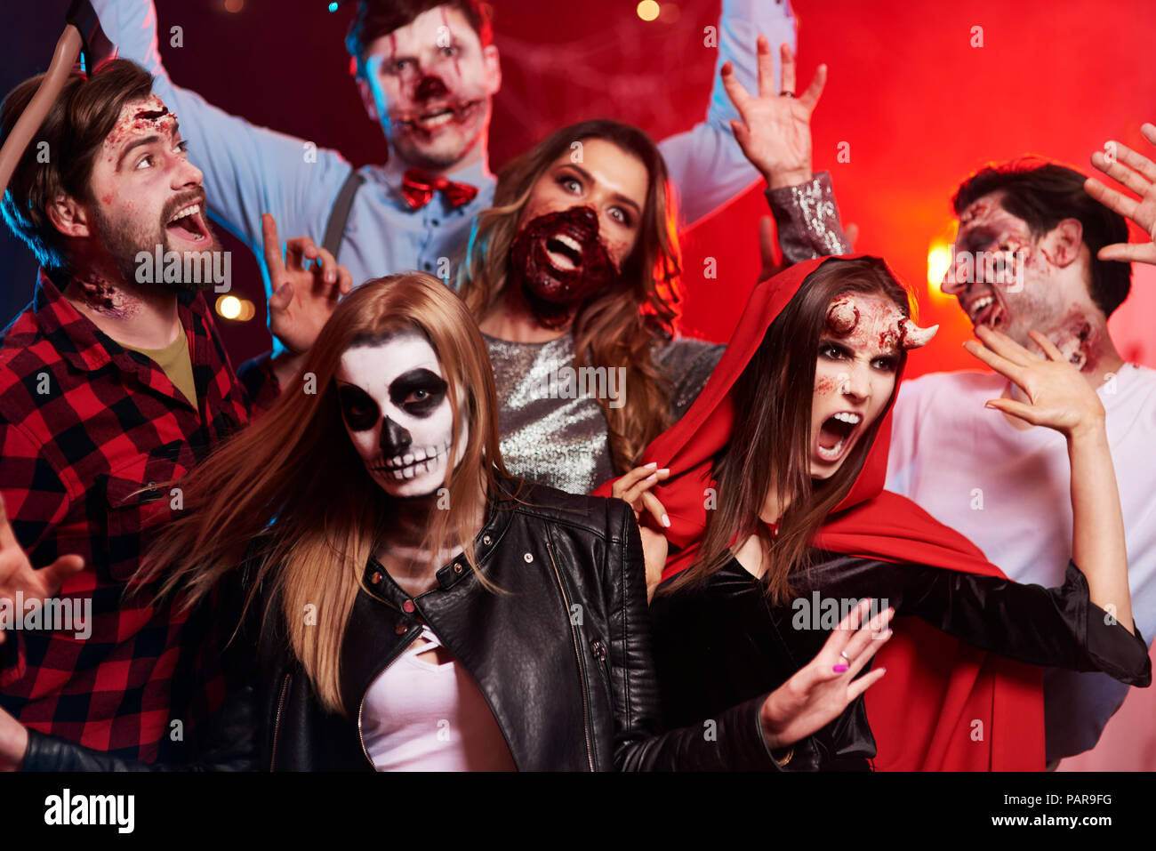 Friends in creepy costumes having fun at Halloween party Stock Photo