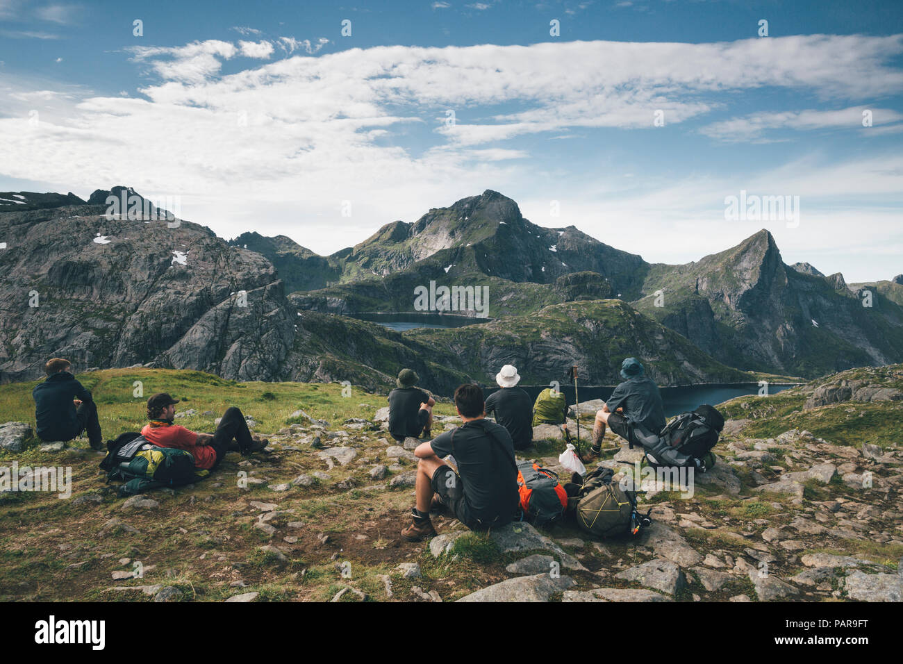 Norway, Lofoten, Moskenesoy, Young men taking a break, looking at the mountains Stock Photo