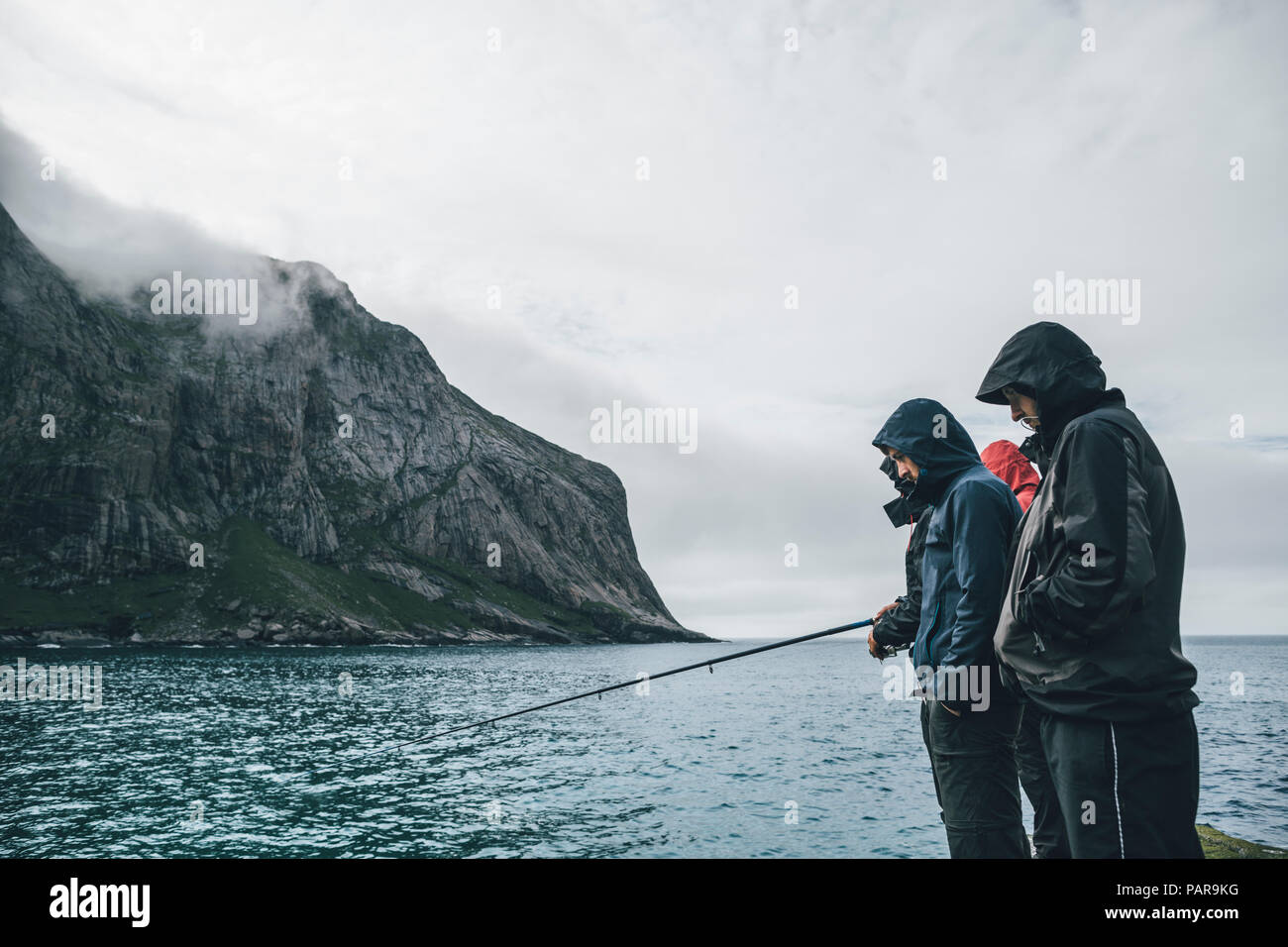 Norway, Lofoten, Moskenesoy, Young men fishing at Horseid Beach Stock Photo