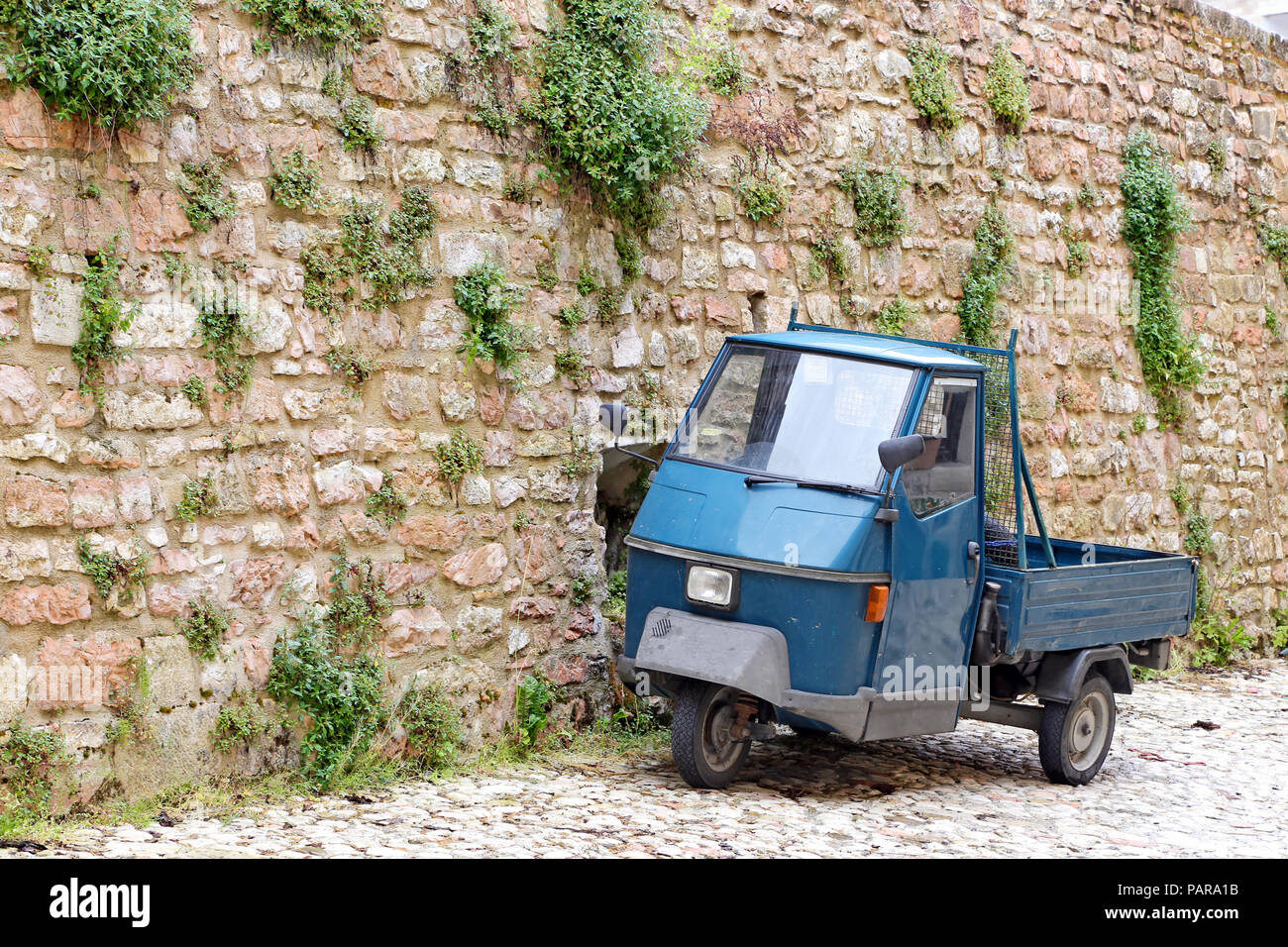 VISSO, ITALY - MAY 31, 2014: a picturesque old alley with dwellings and an ancient italian vehicle Ape Piaggio, on May 31, 2014 in Visso, Marche Italy Stock Photo