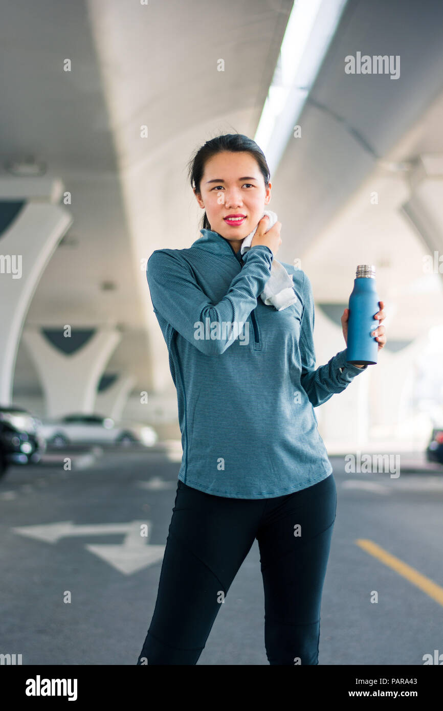 Runner wiping out sweat after workout at the parking lot outside Stock Photo