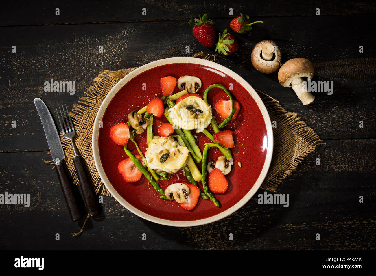 Salad with green asparagus, mushrooms, goat cheese, strawberries and roasted pine nuts Stock Photo