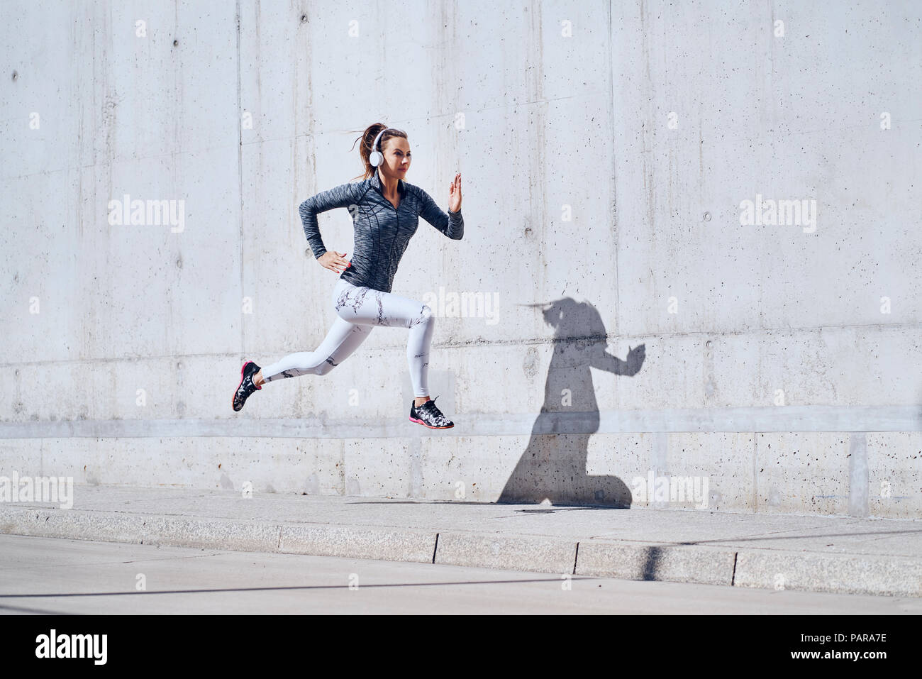 Female jogger with headphones on street Stock Photo