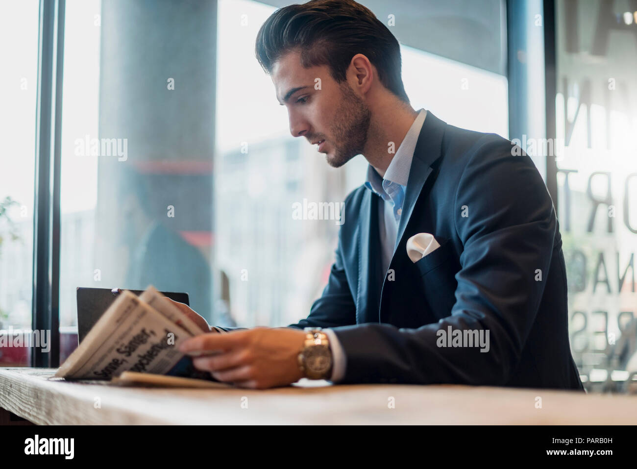 Young businessman reading newspaper in a cafe Stock Photo