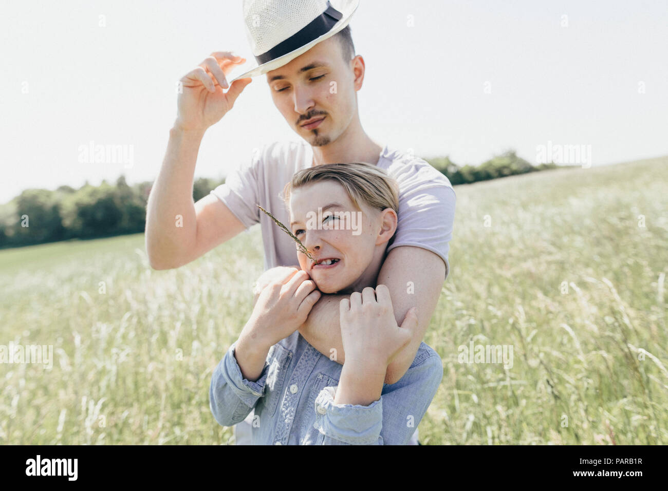 Young man wearing hat and boy on a field Stock Photo