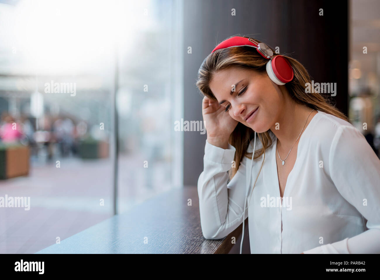 Smiling young woman listening to music with headphones Stock Photo