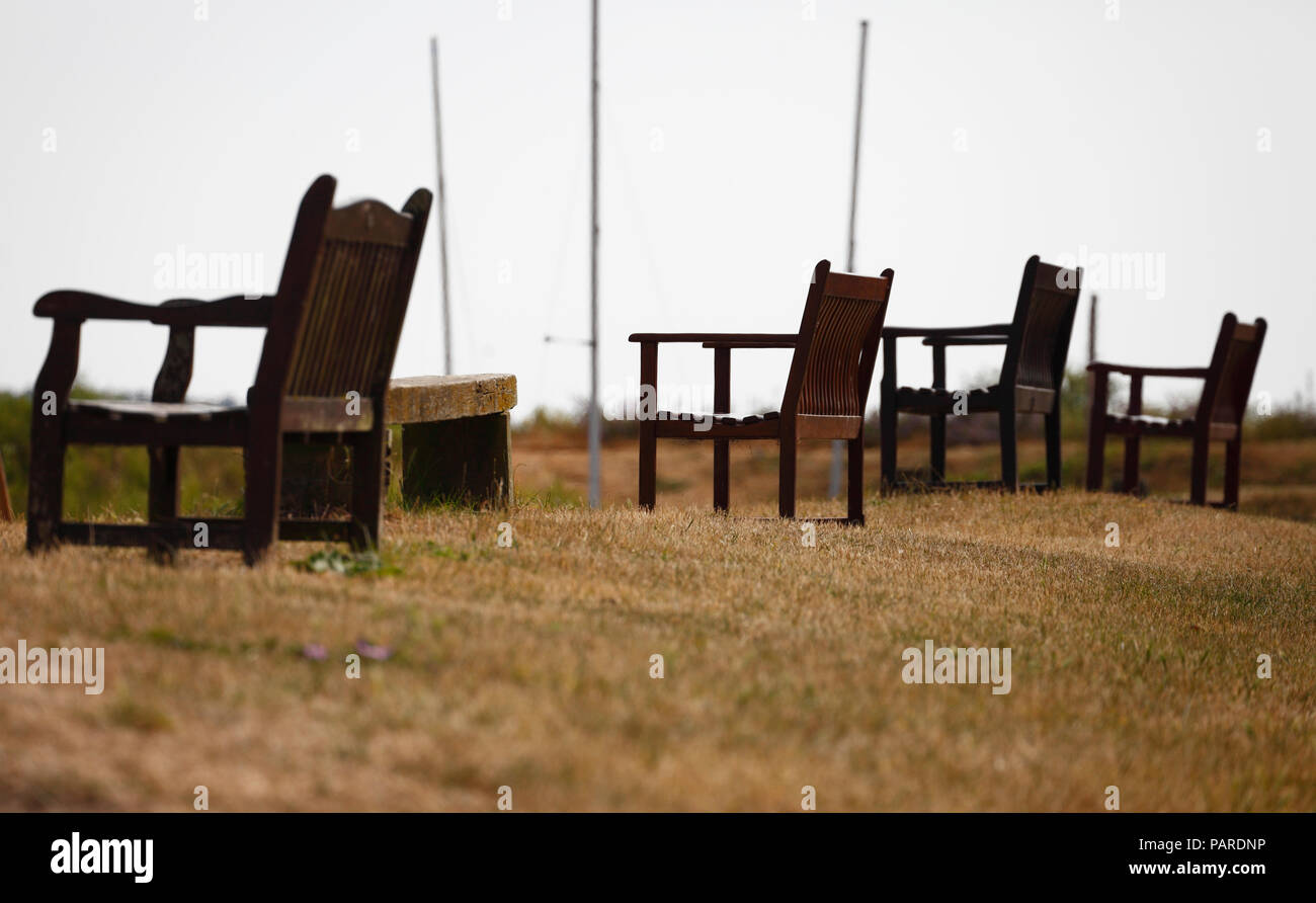 Wooden benches facing the sea at Burnham Overy Staithe on the Norfolk coast. Stock Photo