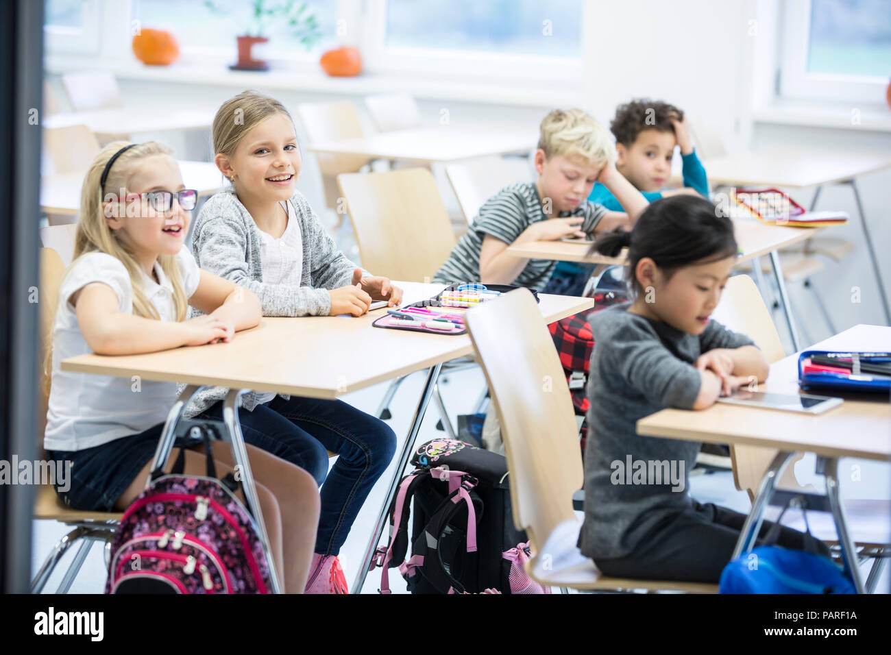 Pupils sitting at desks in class Stock Photo