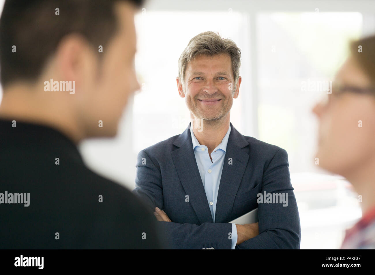 Portrait of smiling man in suit with couple Stock Photo