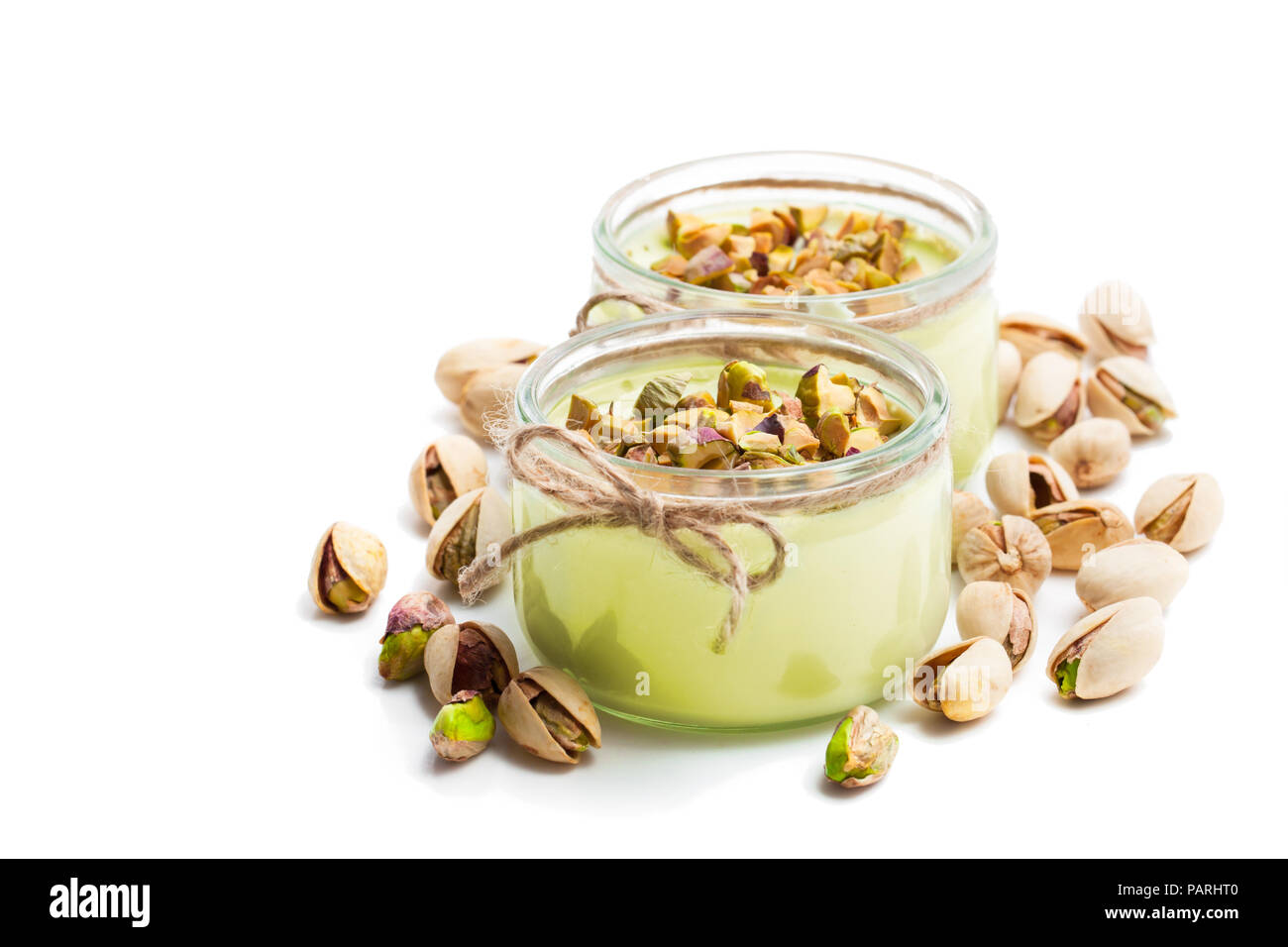 Natural pistachio yogurt in a small glass jar isolated on white Stock