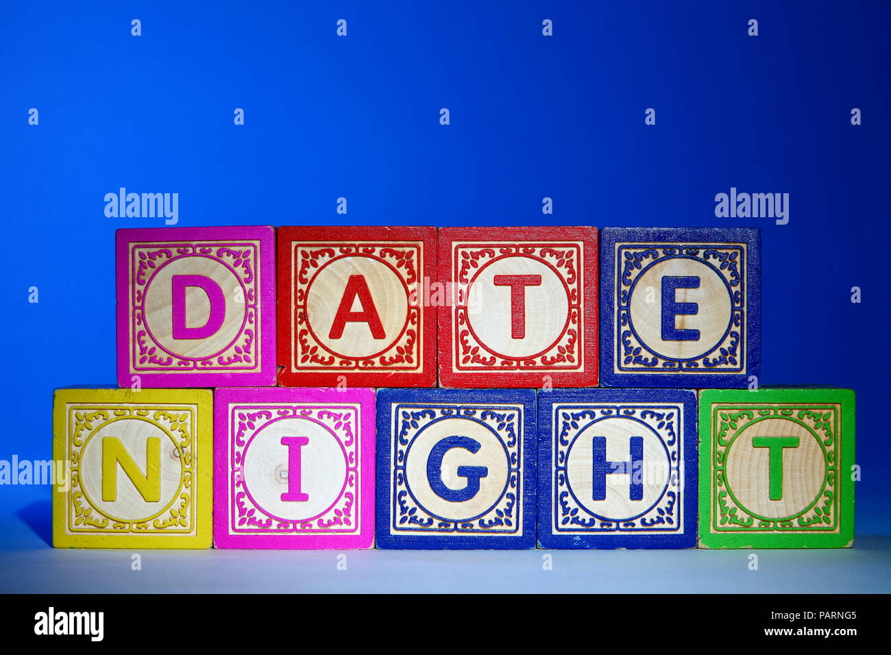 Wooden letter blocks on a blue background spelling out the words date night Stock Photo
